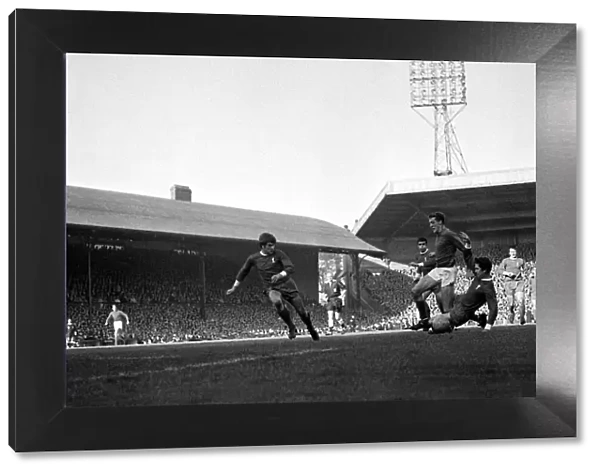 Manchester United goalkeeper Alex Stepney charges through the challenges of Liverpool