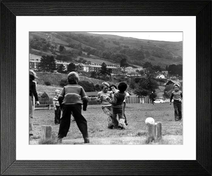Framed Print : Aberfan - Schoolchildren play football on the playing field