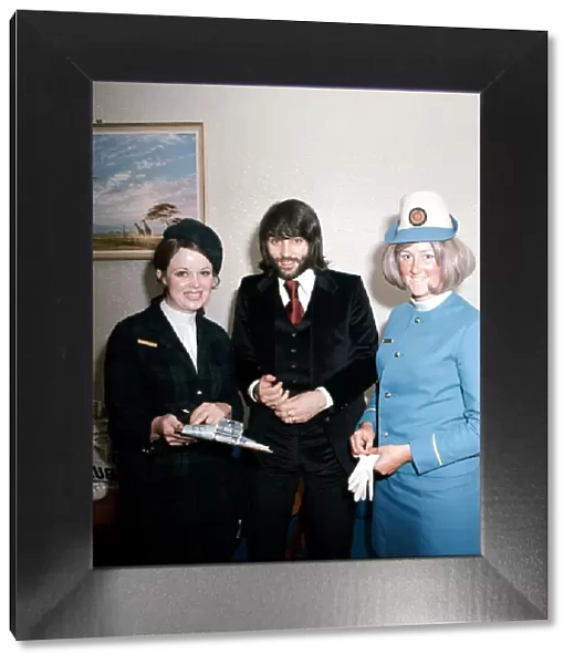 Manchester United footballer George Best with air hostesses before boarding his plane
