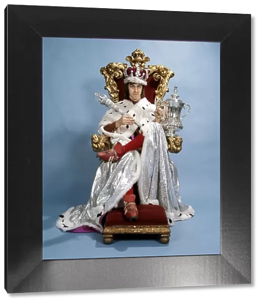 Arsenal footballer Charlie George dressed as a king, sitting on the royal throne wearing