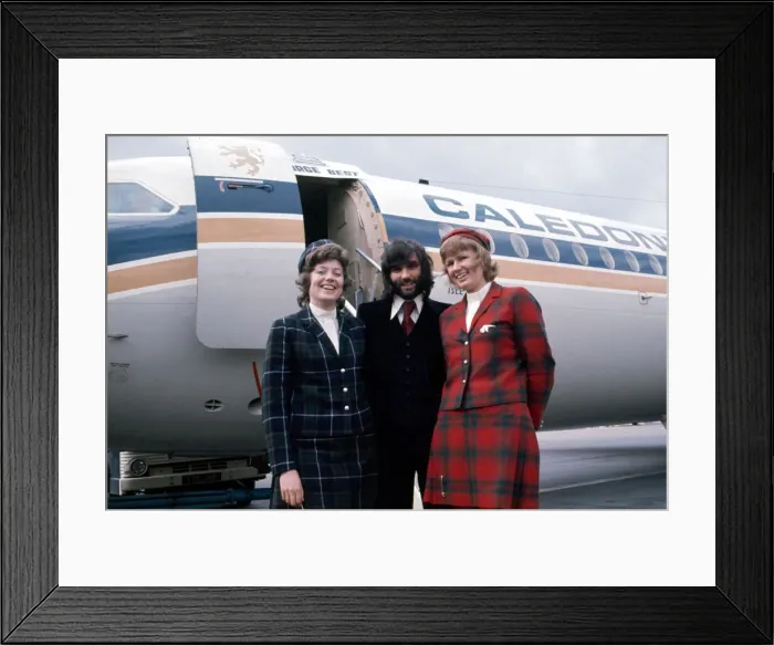 Framed Print : Manchester United footballer George Best with air hostesses before boarding his plane