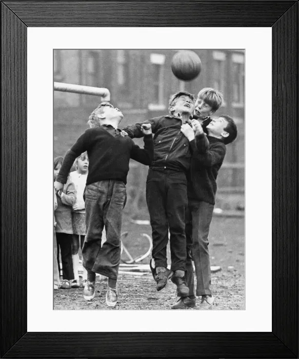 Framed Print : A group of youngsters enjoying a game of football on waste ground on Tyneside