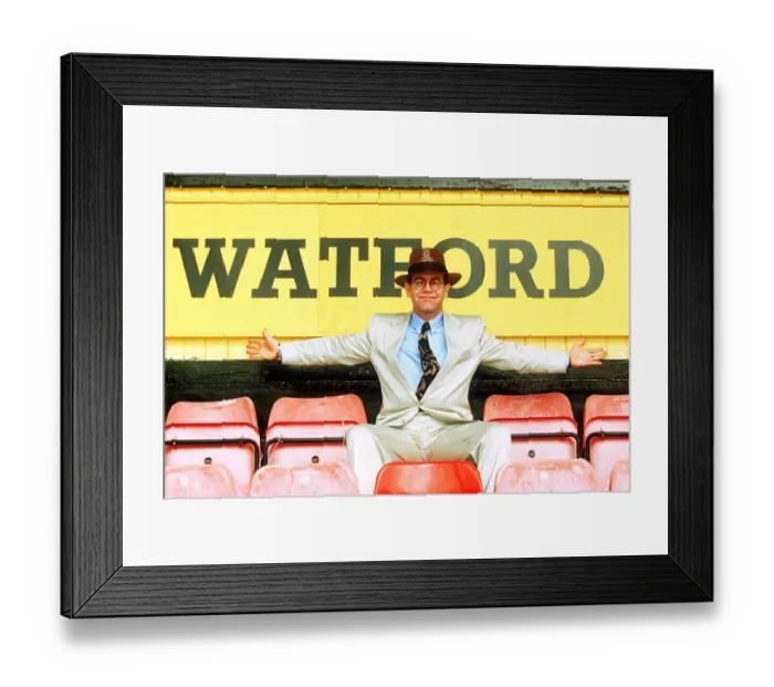 Framed Print : Elton John on rejoining Watford football club as director sitting in front of sign white Framed Print : Elton John on rejoining Watford football club as director sitting in front of sign white