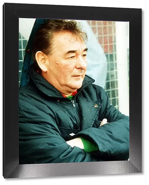 Brian Clough football manager sitting on team bench in football jacket with arms folded