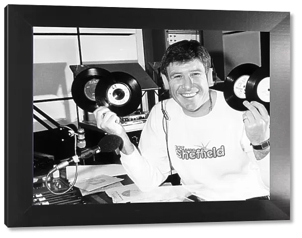 Emlyn Hughes of Liverpool January 1988 holding up records ashe does his DJ bit at