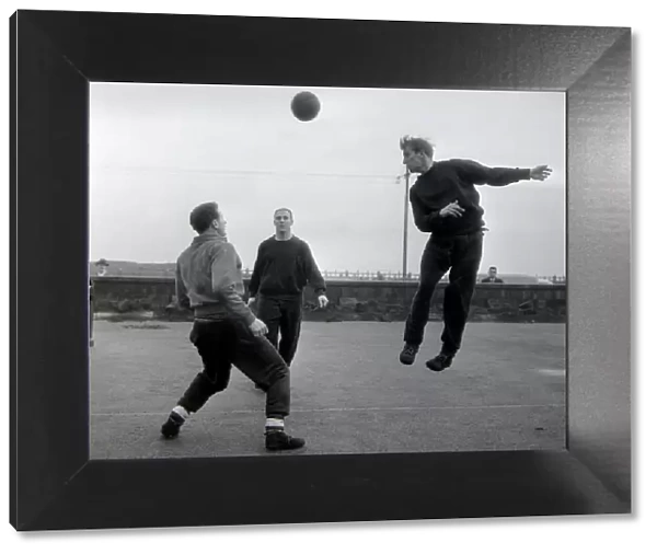 Manchester United player Bobby Charlton jumps up for a header watched by teammates