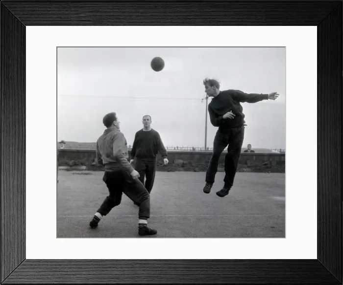 Framed Print : Manchester United player Bobby Charlton jumps up for a header watched by teammates Framed Print : Manchester United player Bobby Charlton jumps up for a header watched by teammates