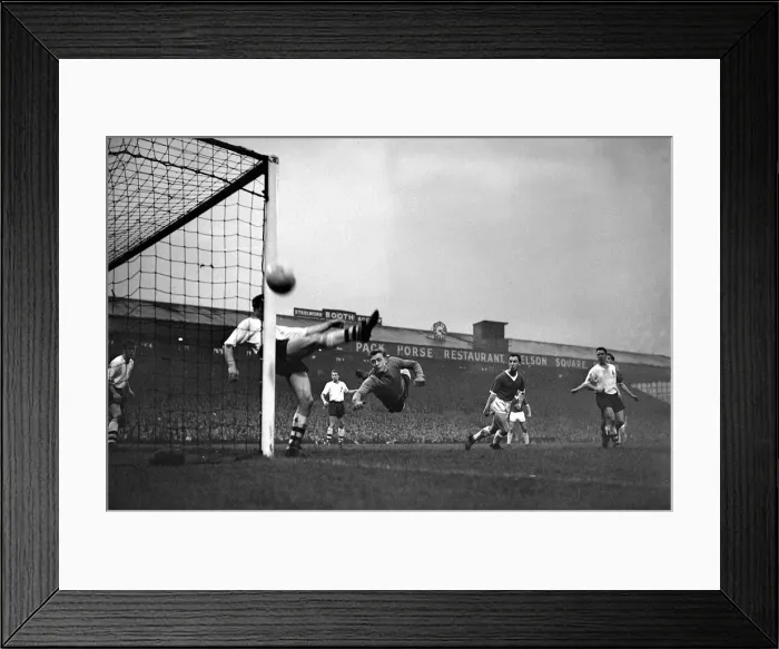 Framed Print : Bolton Wanderers goalkeeper Hopkinson dives across his goal as a defender clears away a