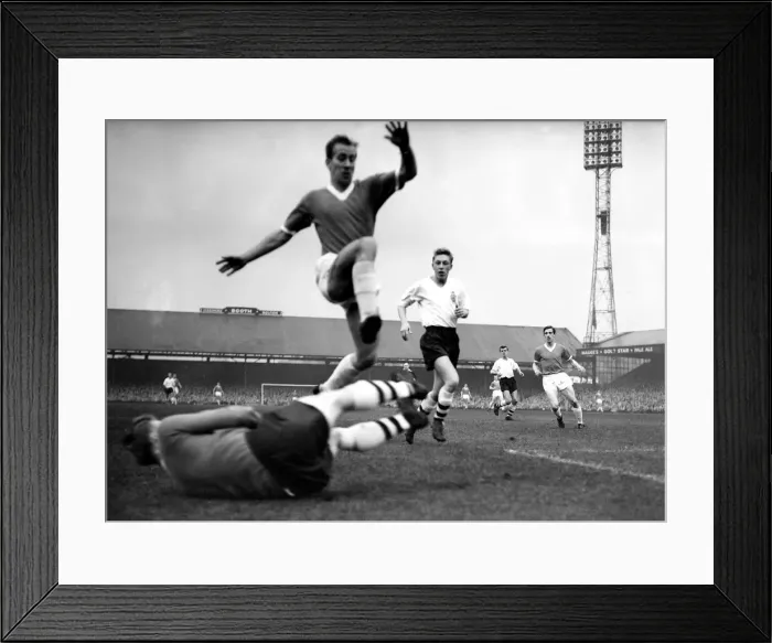 Framed Print : Manchester Uniteds Bobby Charlton jumps to clear the diving body of Bolton