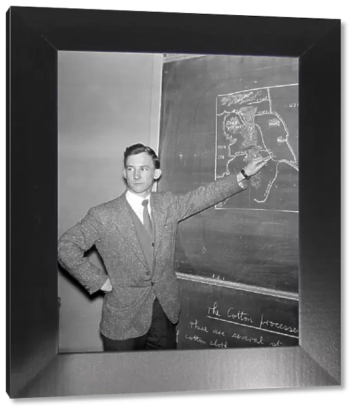 Warren Bradley of Manchester United writing on the chalk board in the classroom at