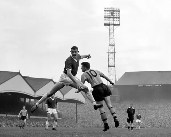 Manchester United defender Bill Foulkes jumps up for a high ball with Broadbent of