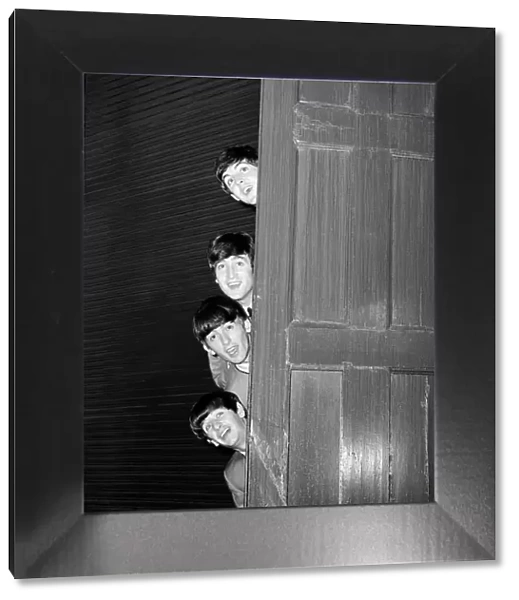 The Beatles peering out from behind a door. before the groups appearence at Sunday Night at the London Palladium, 13 October 1963. Top to bottom are: Paul McCartney, George Harrison, John Lennon, and Ringo Starr