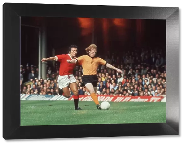 Willie Carr of Wolves with Lou Macari of Manchester United chasing him