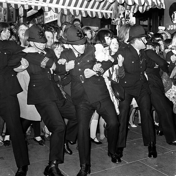 10 July 1964 Police holding back crowds of fans, who are waiting to see The Beatles