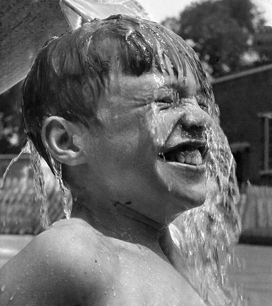 13 years old David Ranswell of London enjoys every minute as his friends pour buckets of