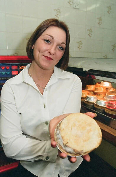 21 year old barmaid Sarah Pilcher holds up a steak and kidney pie in a fish and chip shop