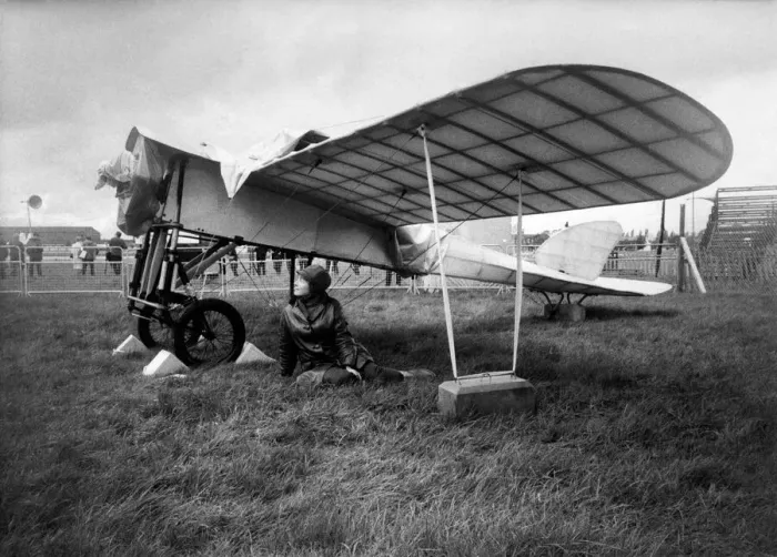 Framed Print : 27 year old Gina McEvoy of Berkshire, sheltering from the rain under the wing of a 1911 Framed Print : 27 year old Gina McEvoy of Berkshire, sheltering from the rain under the wing of a 1911