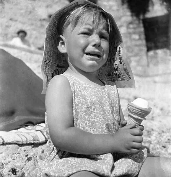 3 years old petis tournant is crying. The sun is too hot for his ice cream
