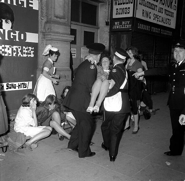 6 July 1964 Police holding back crowds of fans, who are waiting to see The Beatles at