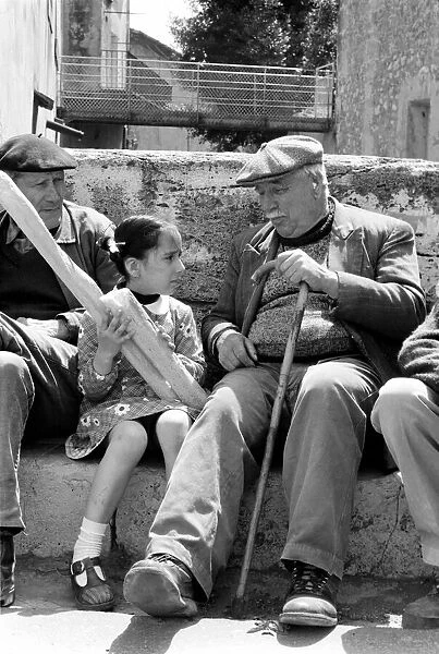 6 year old Nathalie Rustan with her French loaves of bread talks to pensioner Michel