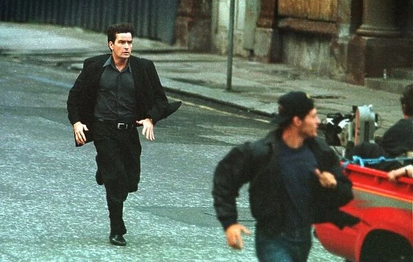 ACTOR CHARLIE SHEEN FILMING IN GLASGOW JULY 1997 IS SEEN RUNNING BEHIND A MOVING