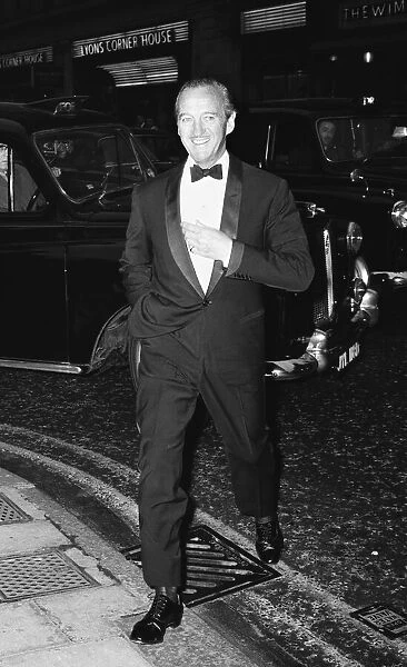 Actor David Niven aarrives at the Prince of Wales Theatre in London for the opening night