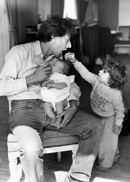 Actor Dustin Hoffman seen here feeding his five week old daughter Rebecca whilst being