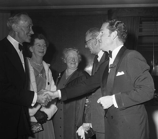 Actor Kenneth More shakes hands with Mrs E Daniels of Portsmouth who was a survivor of