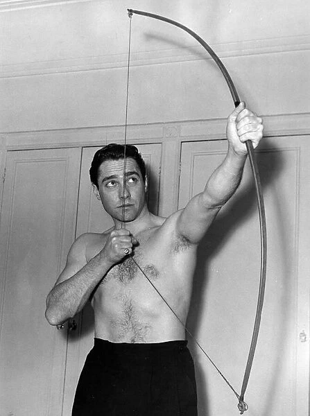 Actor Richard Todd poses with a bow at his home after being chosen to play the part of