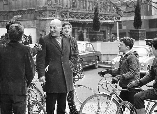 Actor Telly Savalas, surrounded by young fans with bikes