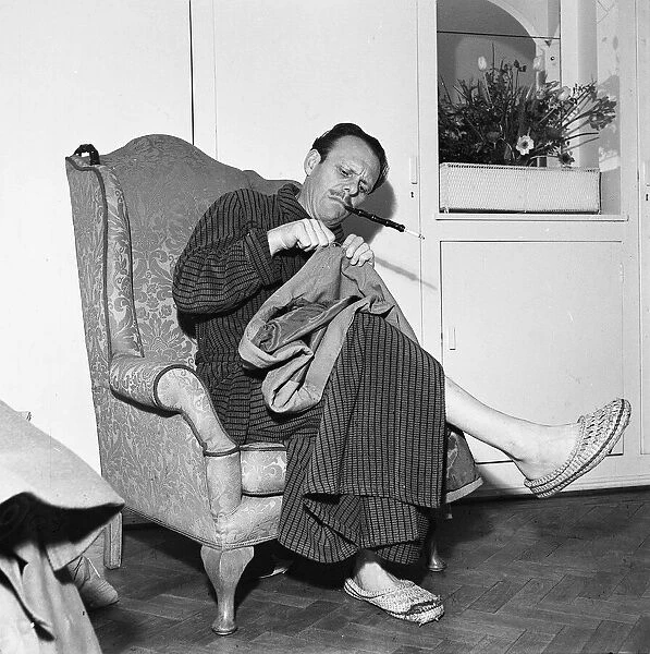 Actor Terry Thomas sitting at home sewing his coat February 1957