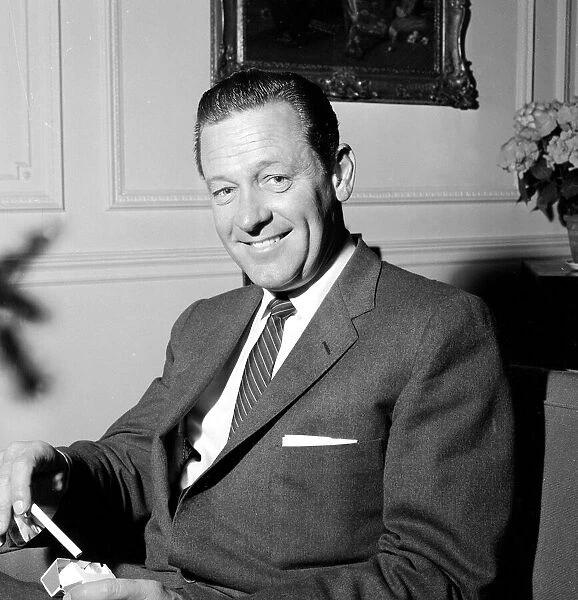 Actor William Holden photographed in his hotel room at the Connaught Hotel while being