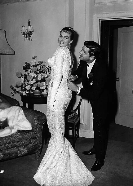 Actress Anita Ekberg has her dress zipped up by her husband Anthony Steel