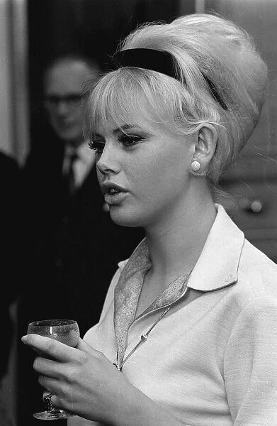 Actress Britt Ekland holding a wine glass, deep in conversation. circa 1960s