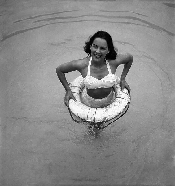 Actress Deidre De Peyer with buoy at Roehampton swimming pool. June 1949 O20117-004