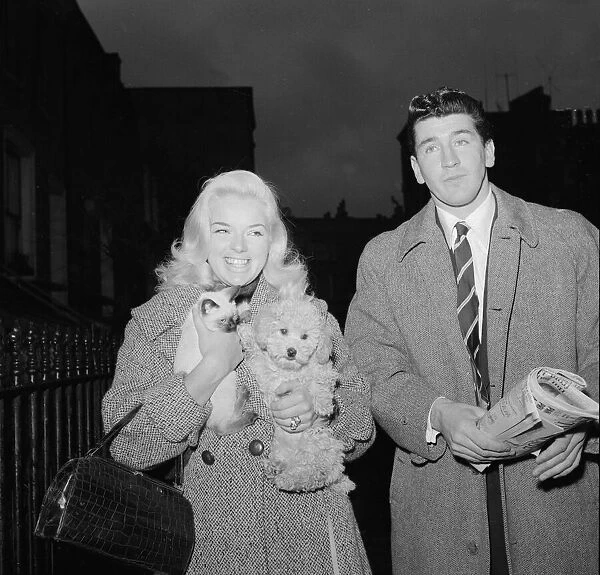 Actress Diana Dors holding her pet dog as she arrives at court on assault charges with