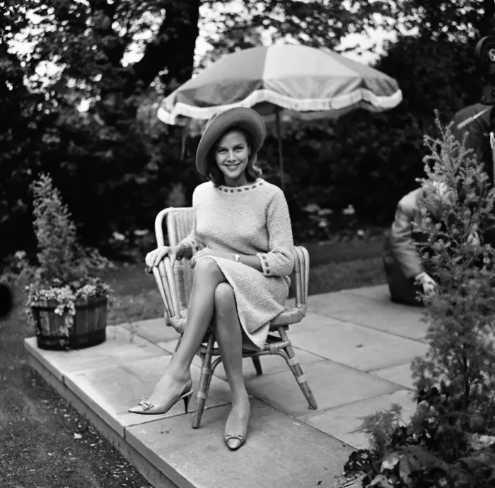 Framed Print : Actress Honor Blackman relaxes in her garden party outfit during the filming of