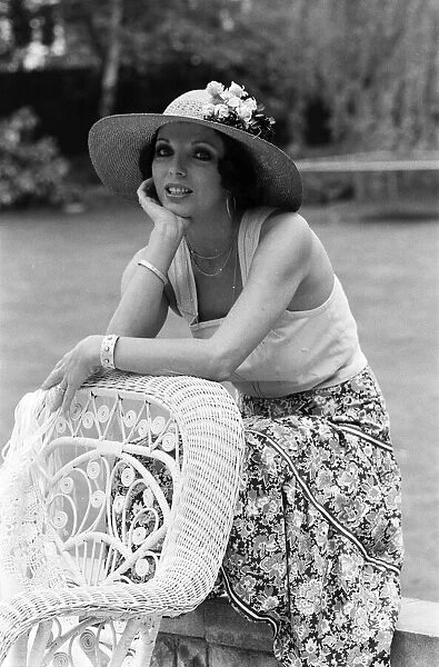 Actress Joan Collins modelling outfits that she will wear on a trip to Tokyo to judge a