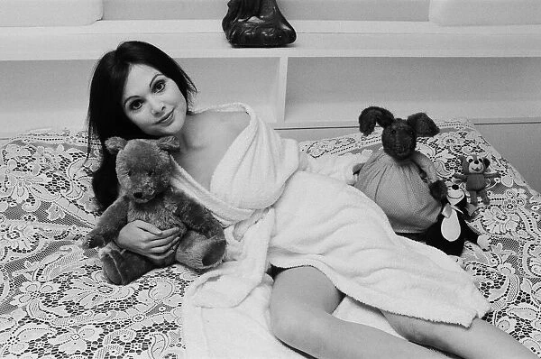 Actress Madeline Smith poses on the bed with her teddy bears. 2nd November 1973