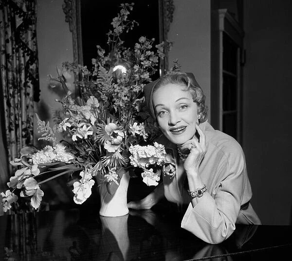 Actress Marlene Dietrich next to a vase of flowers in her hotel room May 1955