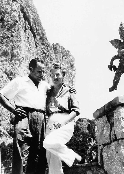 Actress and singer Gracie Fields standing on a rock with her husband Boris Alperouici