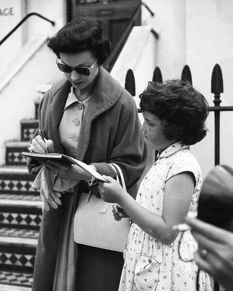 Actress Vivien Leigh signing autographs for a young fan in London August 1956