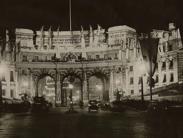 Admiralty Arch flood lit and adorned with White Ensign flags in preparation for
