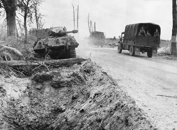 An advancing Allied column passing a damaged German Panther tank on the Falaise road