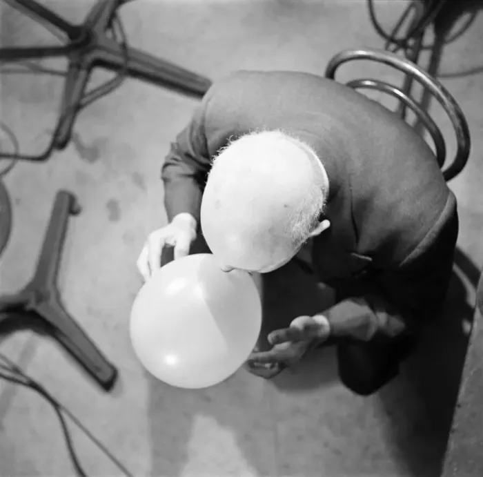 Framed Print : Aerial view of a man blowing up a balloon. November 1952 C5691
