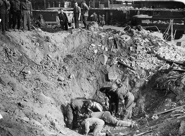Aftermath of a V2 rocket attack on Kew, London. Workmen search the bottom of a