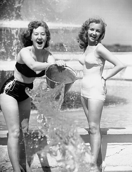 Aileen Kearney (right) and her friend Marjorie Greenhalgh throwing a bucket of water over