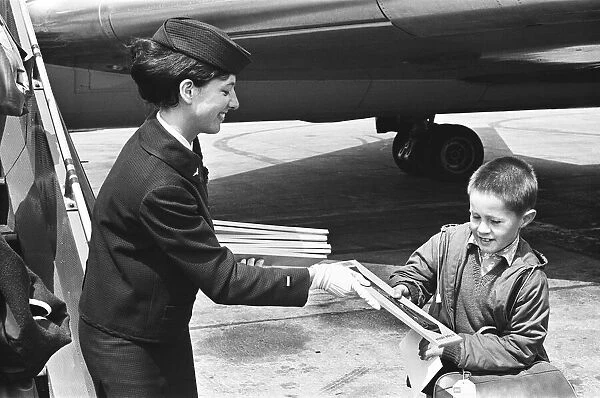 Air hostess with boy at Heathrow airport. 1st June 1965