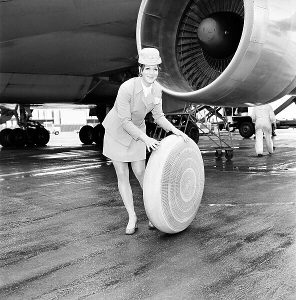 Air hostess sitting by a plane rolling a wheel along. A 2 *** Local Caption