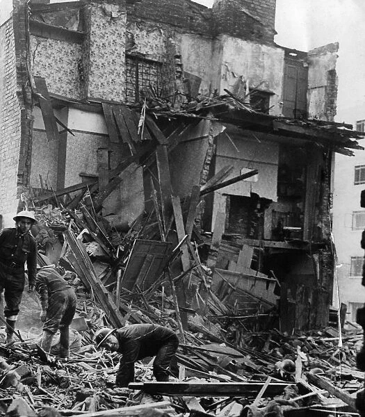Air Raid Precautions workers salvaging in the debris of two working class houses bombed